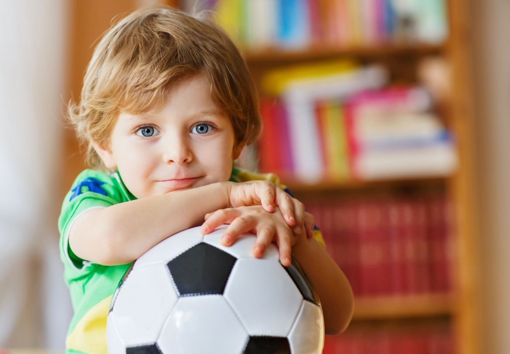 мальчик держит в руках футбольный мяч